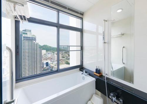 是拉差Citiresort @sea sriracha的一间带白色浴缸和窗户的浴室