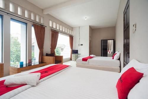 茂物RedDoorz Syariah near Taman Air Mancur Bogor的一间卧室设有两张床和大窗户
