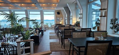 吕瑟希尔吕瑟希尔酒店的一间带桌椅的海景餐厅