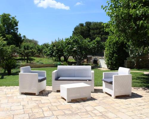 乌真托Villa CICIA的庭院里设有三把白色椅子和一张茶几