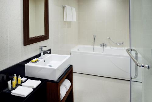 亚的斯亚贝巴斯亚贝巴万豪行政公寓亚 的浴室配有盥洗盆、浴缸和盥洗盆