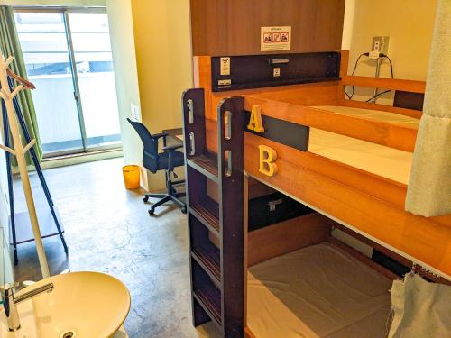 大阪Hostel JIN - Weekly Appartment in Osaka的客房配有双层床和书桌。