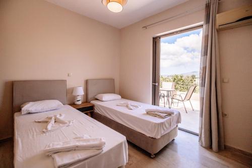 卡拉马孔Nadia Apartments B的酒店客房设有两张床和一个阳台。