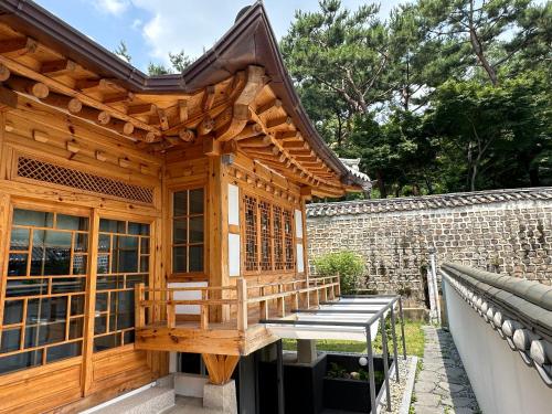 首尔Luxury hanok with private bathtub - SN01的木质建筑,在庭院设有长凳