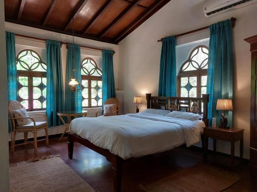 SinquerimMarbella Guest House的一间卧室配有一张带蓝色窗帘和窗户的床。