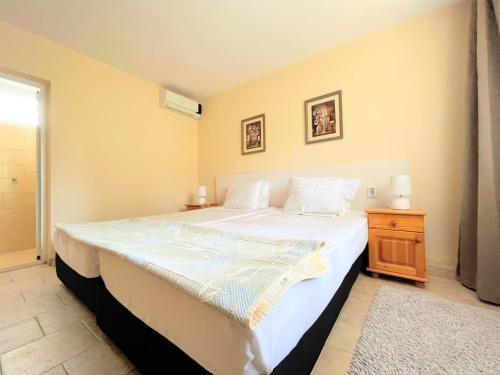 阳光海滩Lotus Family Hotel - Free Parking的一间卧室配有一张白色大床和床头柜