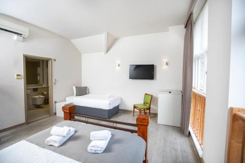 伦敦Arch Hotel的一间带两张床的卧室和一台电视