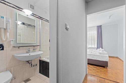 梅杜林Minerva Hotel的一间带水槽、卫生间和镜子的浴室