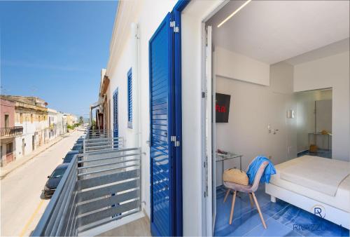 圣维托罗卡波Rivazzurra Beach Rooms的一间卧室配有一张床,阳台设有门