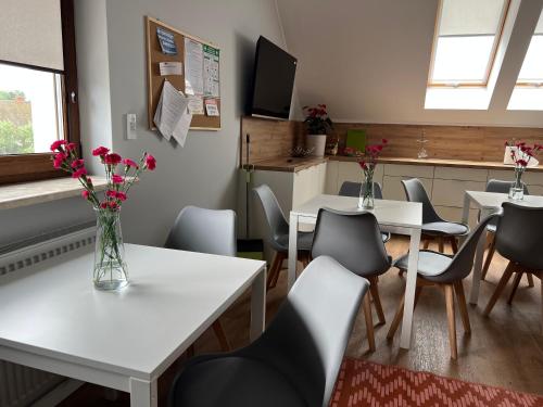 弗罗茨瓦夫Noclegi Budomas Klima-ParkigFree-SmartTv的一间带桌椅和鲜花的用餐室