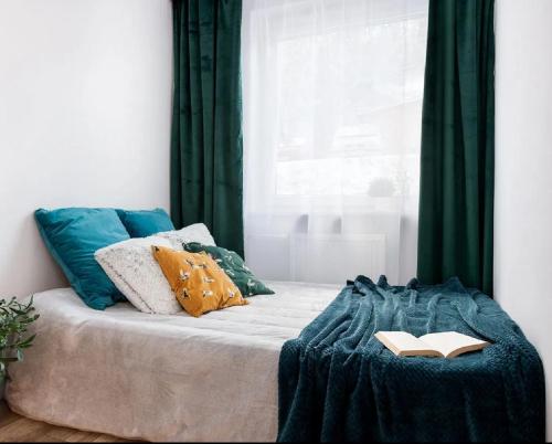 索波特Sun and Sea Apartment Sopot的一张带蓝色毯子的床和一本书