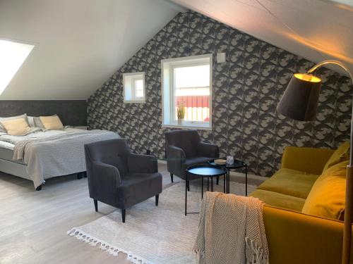 BjörköHamnhuset Björkö的一间卧室配有一张床、一张沙发和椅子
