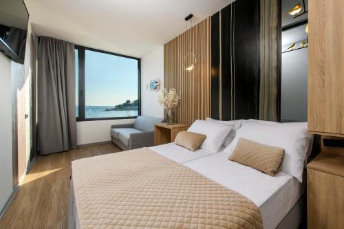 斯普利特Via Mare Luxury Rooms的酒店客房设有一张床和一个大窗户