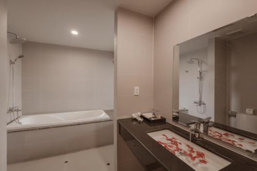 富国布拉格酒店的一间带水槽、浴缸和镜子的浴室