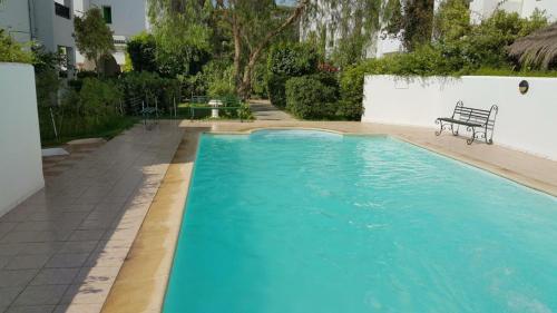 纳布勒Appartement de charme的一座蓝色游泳池,旁边设有长凳