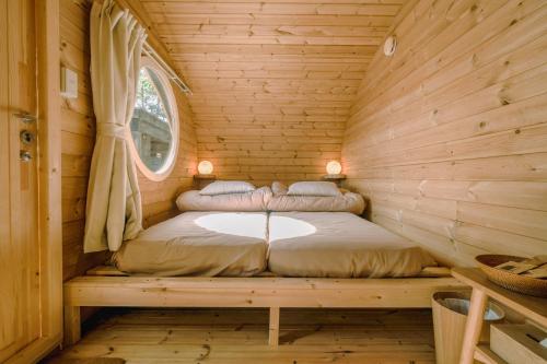 阿扎格瓦つながるキャンプリゾートQOONEL+的小木屋内的一张床位,设有窗户