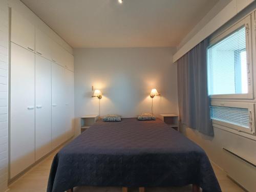 索特Näköalahuoneisto 412的一间卧室配有一张带蓝色毯子的床和窗户。