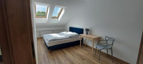 SzuminkaVilla Nova的一间小卧室,配有一张床和一张桌子及椅子