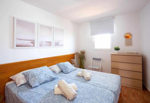 梅罗那瑞斯Apartamento Maypa 5 Mar的一间卧室配有蓝色的床和2条毛巾