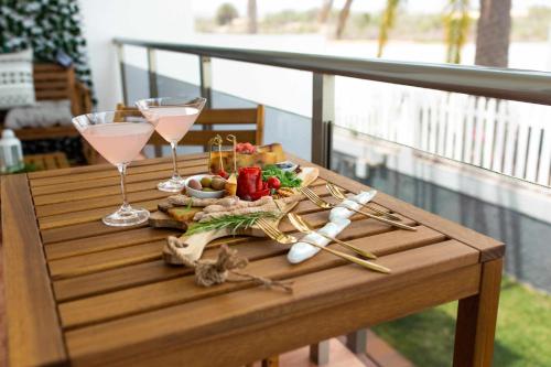 梅罗那瑞斯Apartamento Maypa 5 Mar的阳台上配有带酒杯和食物的桌子