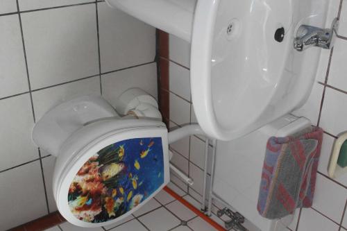 滨湖克拉科Ferienquartiere Roloff的浴室设有卫生间,座位上画有画作