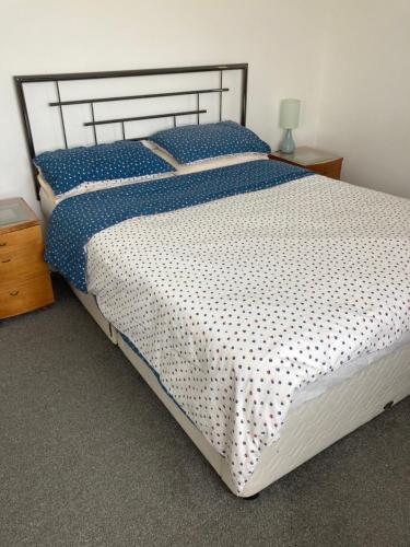 米勒姆HH Accommodation的一间卧室配有一张带蓝白色床单的大床