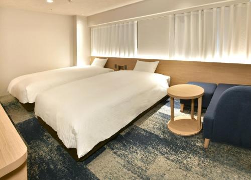 名古屋名古屋荣华盛顿广场酒店的一间卧室配有两张床和蓝色的沙发