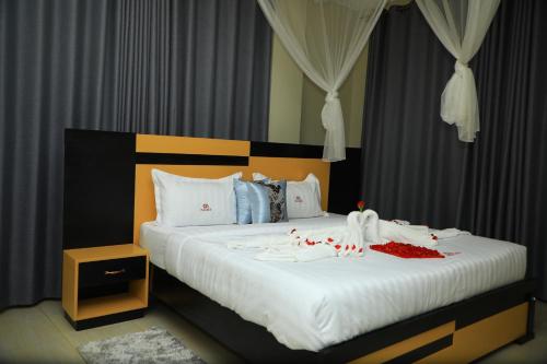坎帕拉Galaxy Motel Kampala的卧室配有一张白色大床,装饰有