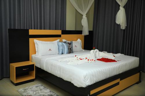 坎帕拉Galaxy Motel Kampala的一张配有白色床单和红色装饰的大床