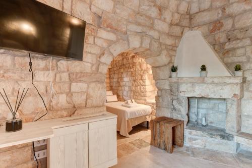 莫诺波利APOLLO House of Puglia的带石墙的客房设有石制壁炉。