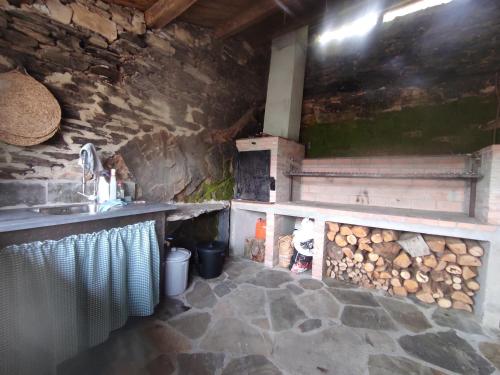 PiluPeta Casa de Aldea的厨房配有柜台和带原木的炉灶。