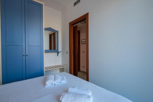 卡普多兰多Residence L'Arcipelago Appartamenti Fronte Mare con Ampio Balcone的卧室配有白色床和毛巾