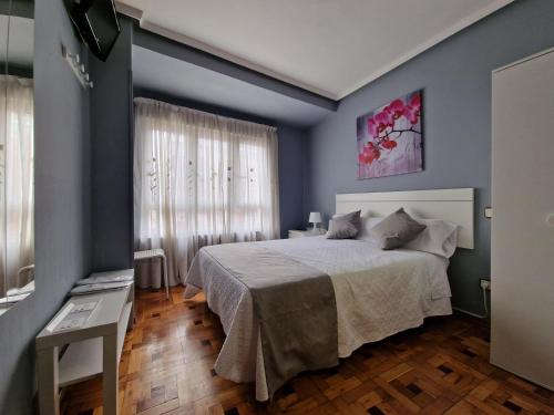 奥维多菲达尔戈旅馆的一间卧室配有一张带蓝色墙壁的大床