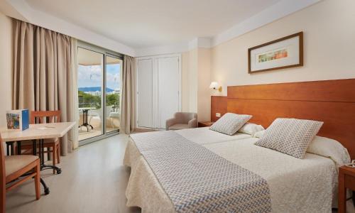 卡拉米洛巴伊亚格兰德时尚公寓式酒店的酒店客房设有一张床铺、一张桌子和一个阳台。
