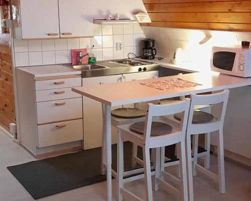 YlitornioKaremajat Special cottage的一个带桌子和两张凳子的小厨房