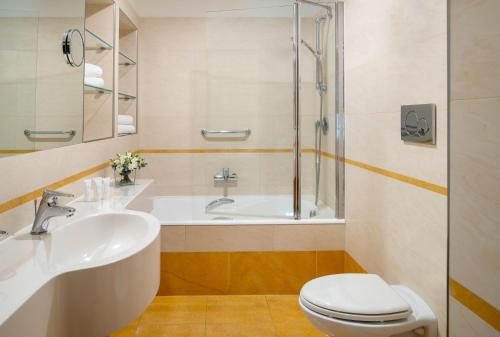 米兰UNAHOTELS Galles Milano的浴室配有盥洗盆、卫生间和浴缸。
