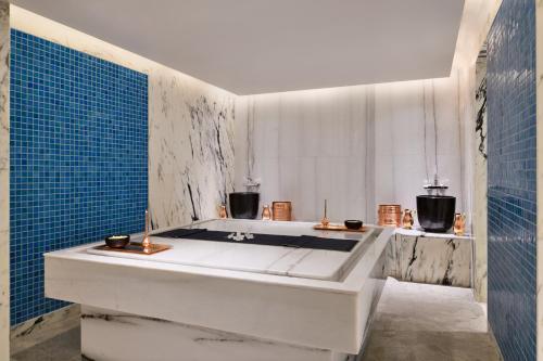 班加罗尔Mulberry Shades Bengaluru Nandi Hills - a Tribute Portfolio Resort的浴室设有浴缸,铺有蓝色瓷砖。