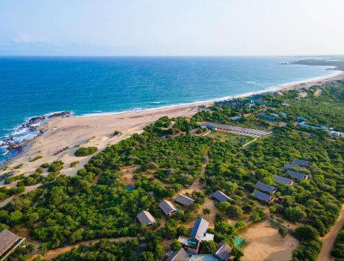 雅拉Jetwing Safari Camp的享有海滩的空中景致,设有房屋和海洋
