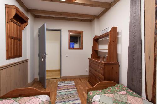Barentsburg柏默尔旅舍的一间卧室配有一张床、梳妆台和衣柜。