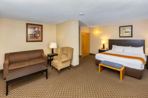 埃德蒙顿埃德蒙顿城中心康福特茵酒店的配有一张床和一把椅子的酒店客房