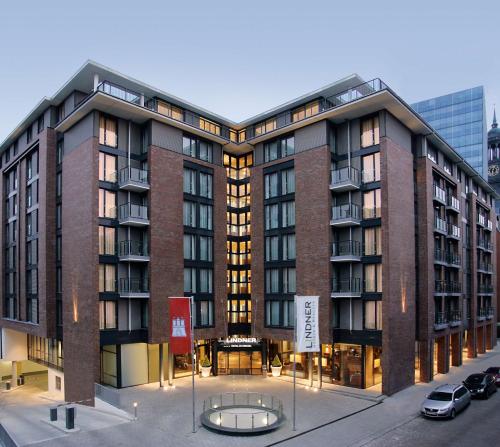 汉堡Lindner Hotel Hamburg am Michel, part of JdV by Hyatt的一座大型砖砌建筑,前面设有桌子