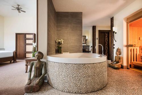 汉堡Park-Hotel Hagenbeck的一间带浴缸的浴室,两座雕像环绕着它
