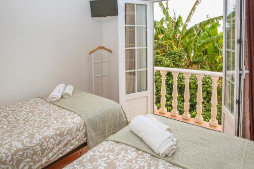 劳林哈Pata da Gaivota Boutique House的客房设有两张床和一个阳台。