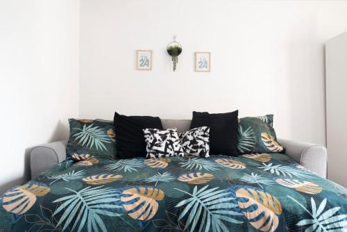 塞尔吉Boho Chic-27m²-Proche de Paris的床上有色彩缤纷的毯子和枕头