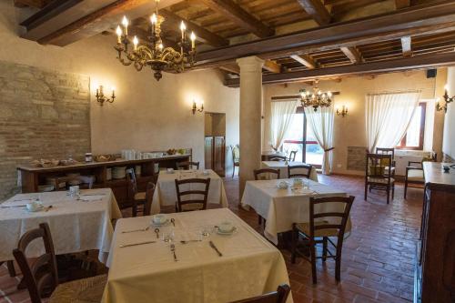 法诺Locanda di Montegiove的餐厅配有白色的桌椅和吊灯