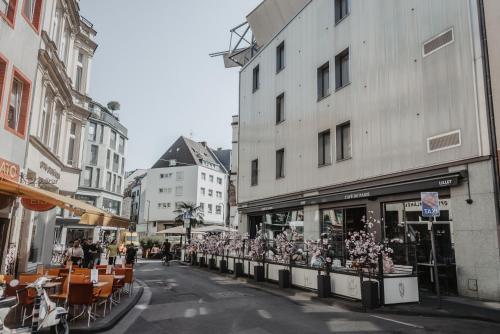 科隆Boutique Hotel Cologne的一条城市街道,街道上设有建筑和桌椅