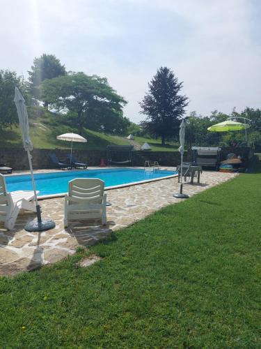 San Cristoforoappartamento con piscina tra la colline的庭院内带椅子和遮阳伞的游泳池