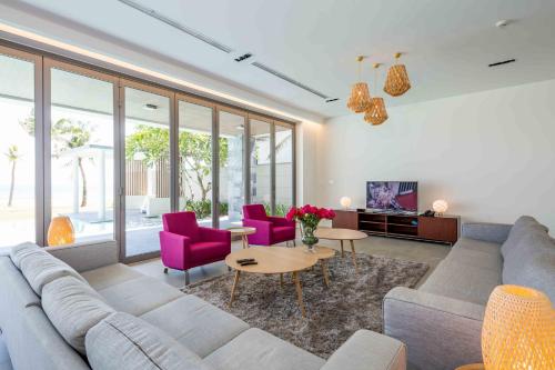 岘港Vacation Home Ocean Villas的带沙发和紫色椅子的客厅