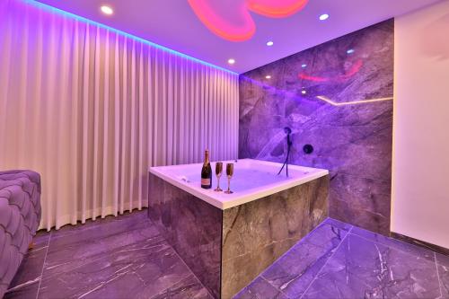 海法חלום מול הים - סוויטת נופש יוקרתית עם ג'קוזי ונוף לים的浴室配有带紫色照明的浴缸