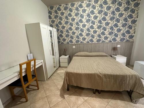 米兰奇塔斯都妮酒店的一间卧室配有一张床、梳妆台和书桌